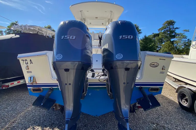 Slide: The Image of 2006 Regulator 23 Forward Seating boat with twin Yamaha 150 engines, parked on gravel. - 5