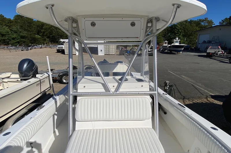 Slide: The Image of 2006 Regulator 23 Forward Seating boat with white interior, parked outdoors. - 18