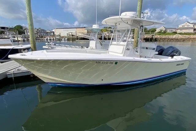 Slide: The Image of 2006 Regulator 23 Forward Seating boat docked in a marina under a cloudy sky. - 22