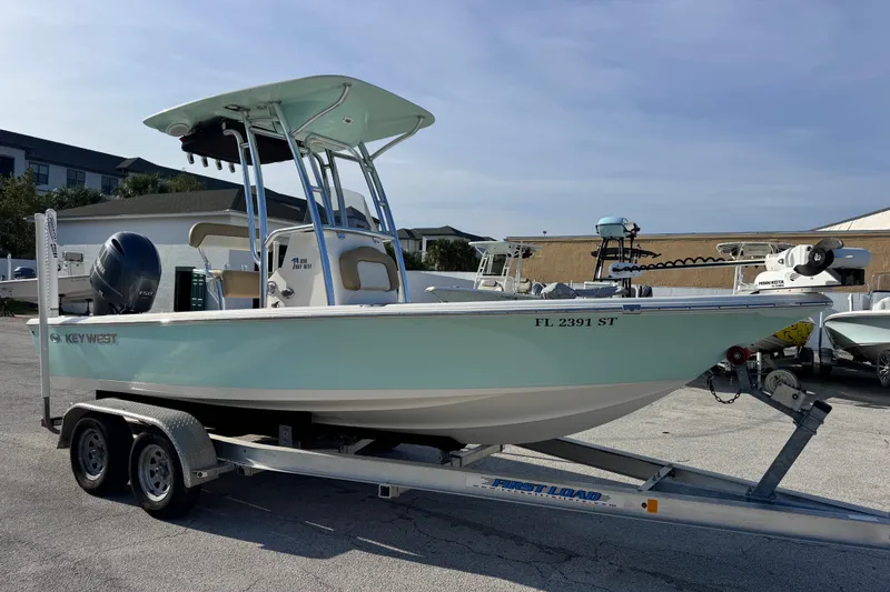 Slide: The Image of 2020 Key West 210 Bay Reef boat on trailer, featuring a sleek design and outboard motor. - 18