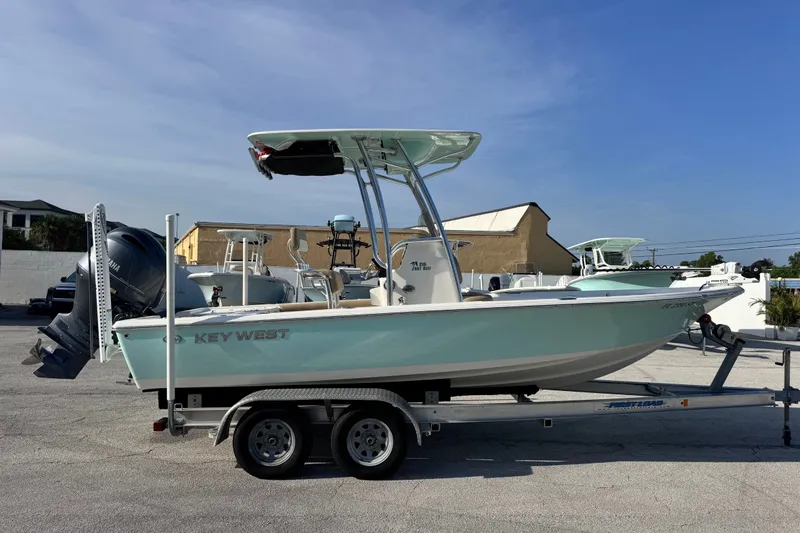 Slide: The Image of 2020 Key West 210 Bay Reef boat on trailer, parked outdoors under clear sky. - 17