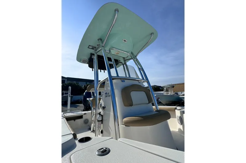 Slide: The Image of 2020 Key West 210 Bay Reef boat with T-top and seating, under clear blue sky. - 20