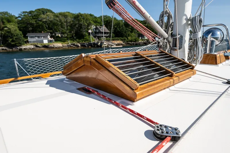 Slide: The Image of Hinckley Sou'wester 42 MKII sailboat deck with wooden hatch, 1995 model, near scenic shoreline. - 45