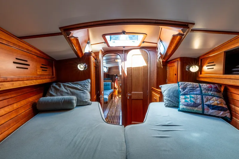 Slide: The Image of Interior of 1995 Hinckley Sou'wester 42 MKII sailboat, featuring cozy wooden cabin with twin beds. - 34