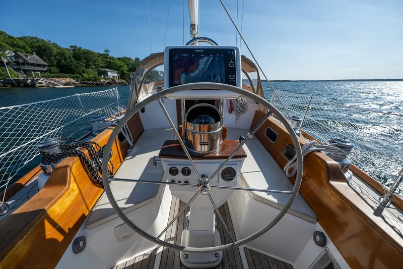 Slide: The Image of Hinckley Sou'wester 42 MKII sailboat cockpit with steering wheel, ocean view, and navigation equipment. - 59