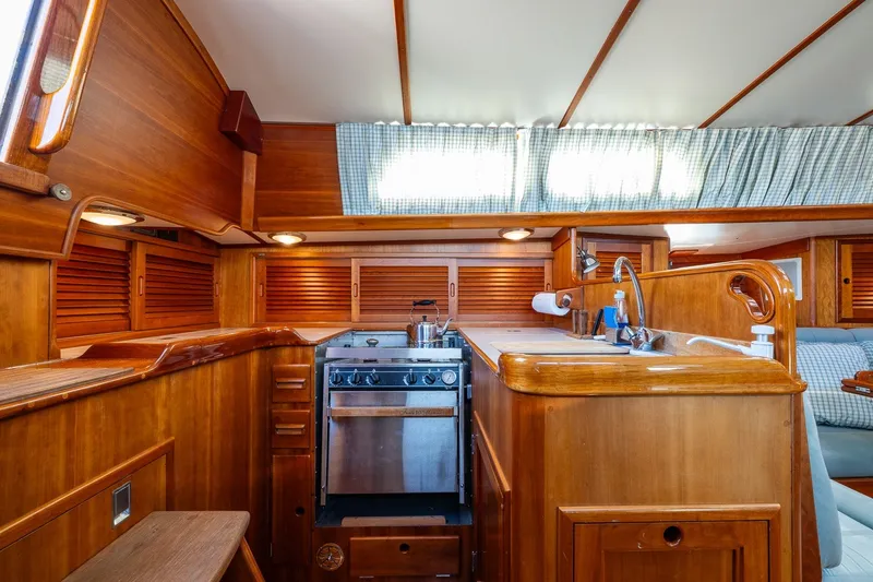 Slide: The Image of Hinckley Sou'wester 42 MKII 1995 yacht interior with wooden cabinetry and compact kitchen area. - 20