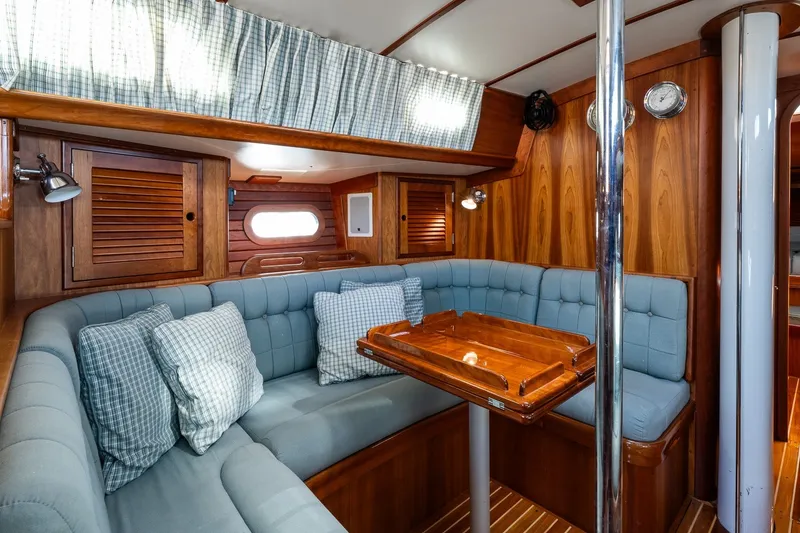 Slide: The Image of Cozy interior of 1995 Hinckley Sou'wester 42 MKII sailboat with wood paneling and cushioned seating. - 23