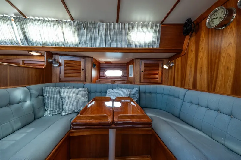 Slide: The Image of Interior of 1995 Hinckley Sou'wester 42 MKII yacht with blue seating and wooden table. - 26