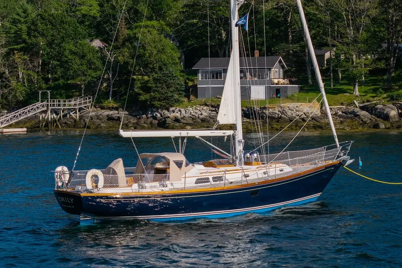 The Image of Hinckley Sou'wester 42 MKII sailboat from 1995 anchored near a scenic shoreline. - 0