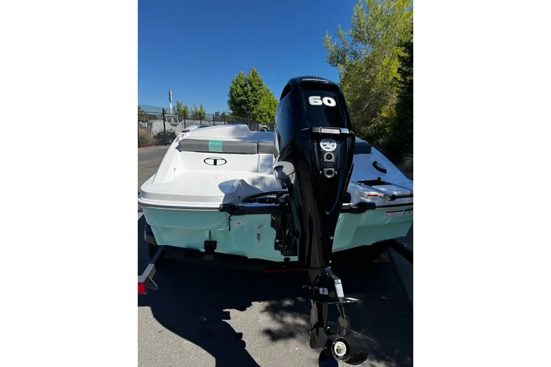Slide: The Image of 2026 Tahoe T16 boat with a 60 HP Mercury outboard motor, parked outdoors. - 72