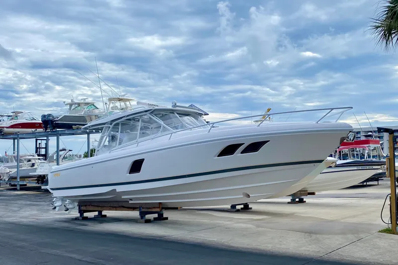 Slide: The Image of 2020 Intrepid 407 Cuddy boat on display at a marina under cloudy skies. - 1