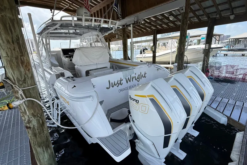 Slide: The Image of 2020 Intrepid 407 Cuddy boat docked with triple outboard engines. - 20