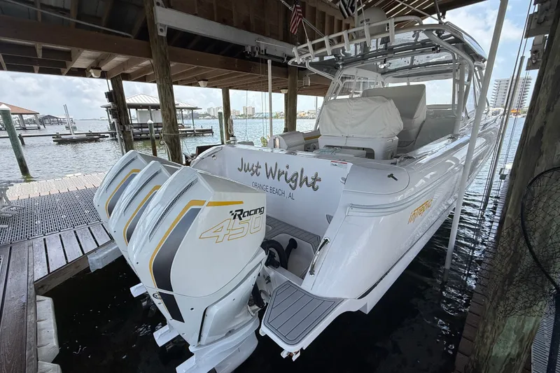 Slide: The Image of 2020 Intrepid 407 Cuddy boat docked, featuring powerful triple outboard engines. - 4