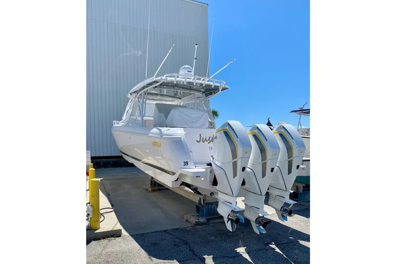 Slide: The Image of 2020 Intrepid 407 Cuddy boat with triple outboard engines, docked outdoors. - 3