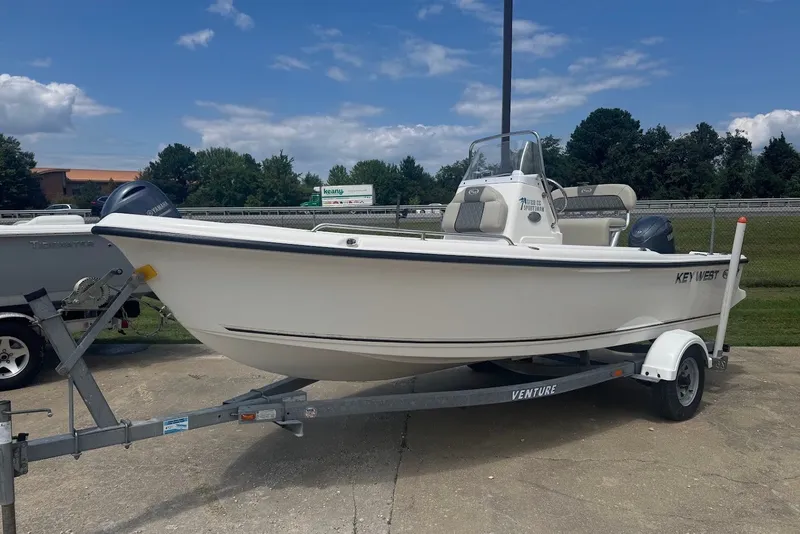 The Image of 2027 Key West 1720 Center Console boat on trailer, parked outdoors under blue sky. - 1