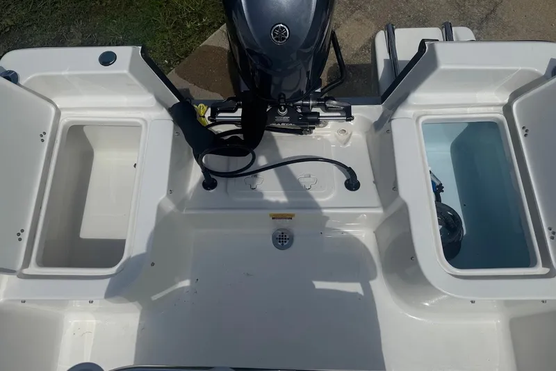 Slide: The Image of 2027 Key West 1720 Center Console boat with open storage compartments and motor. - 11