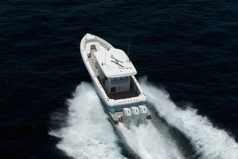 Slide: The Image of 2023 Intrepid 427 Nomad FE boat cruising on open water, rear view. - 2