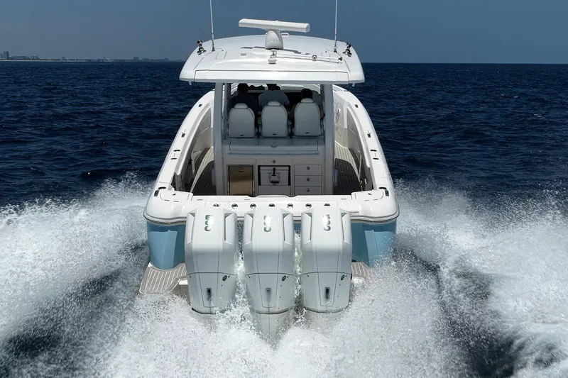 Slide: The Image of 2023 Intrepid 427 Nomad FE boat cruising on open water, rear view. - 7