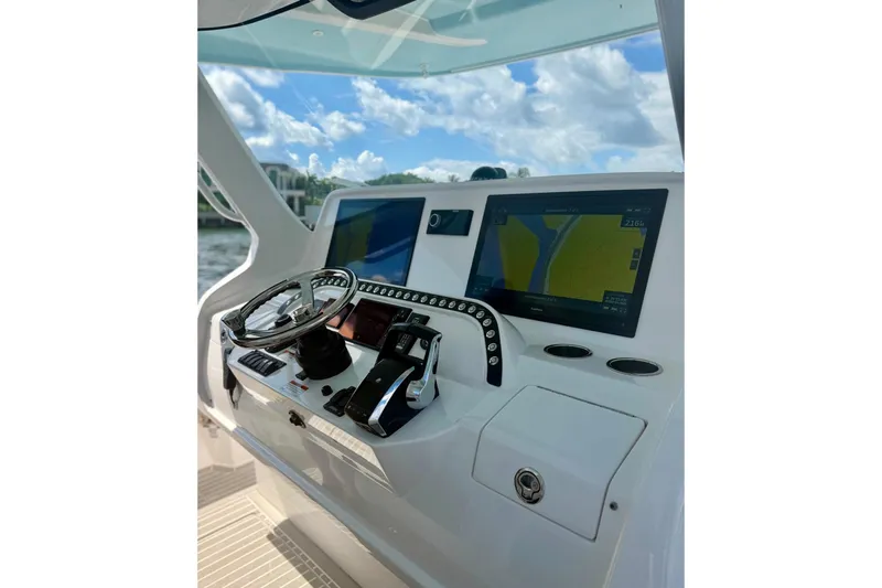 Slide: The Image of Control panel of 2023 Intrepid 427 Nomad FE boat with navigation screens and steering wheel. - 11
