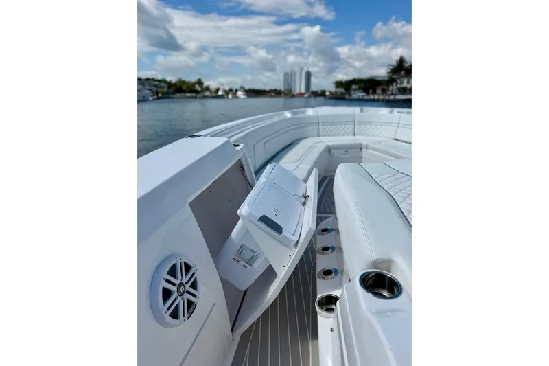 Slide: The Image of 2023 Intrepid 427 Nomad FE boat interior with luxurious seating and cup holders on a sunny day. - 23