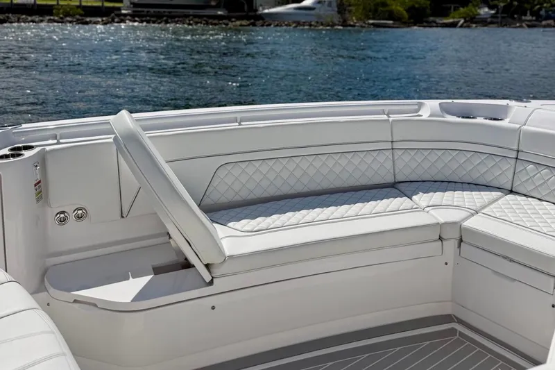Slide: The Image of Luxurious seating on 2023 Intrepid 427 Nomad FE boat, featuring diamond-stitched upholstery by the water. - 19