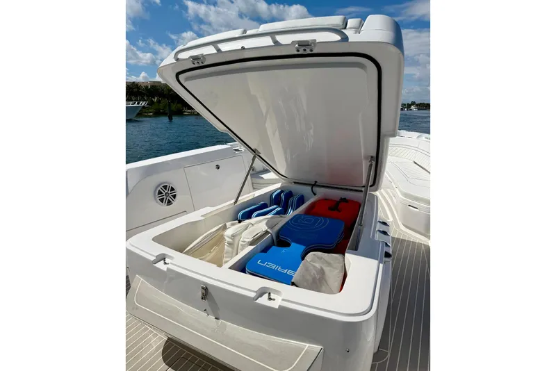 Slide: The Image of Open storage compartment on 2023 Intrepid 427 Nomad FE boat, featuring life jackets and gear. - 22