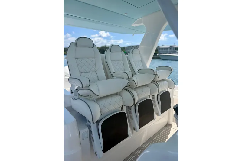 Slide: The Image of Luxurious seating on the 2023 Intrepid 427 Nomad FE boat, featuring elegant white upholstery. - 14