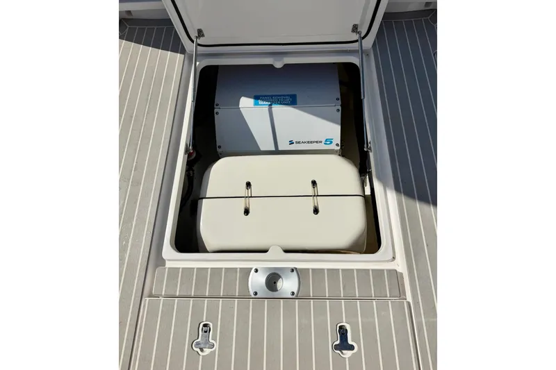 Slide: The Image of Open hatch on 2023 Intrepid 427 Nomad FE, revealing Seakeeper 5 stabilizer unit. - 33