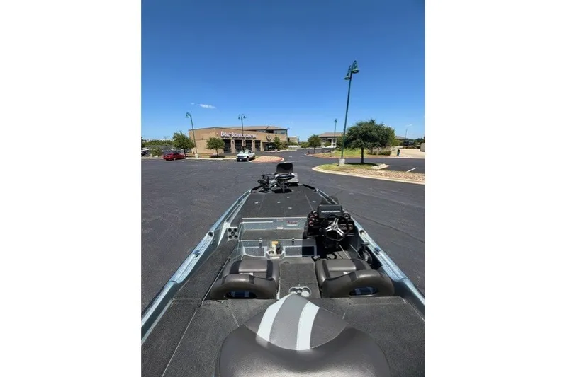 Slide: The Image of 2018 Bass Cat Caracal boat parked near a service center under a clear blue sky. - 6
