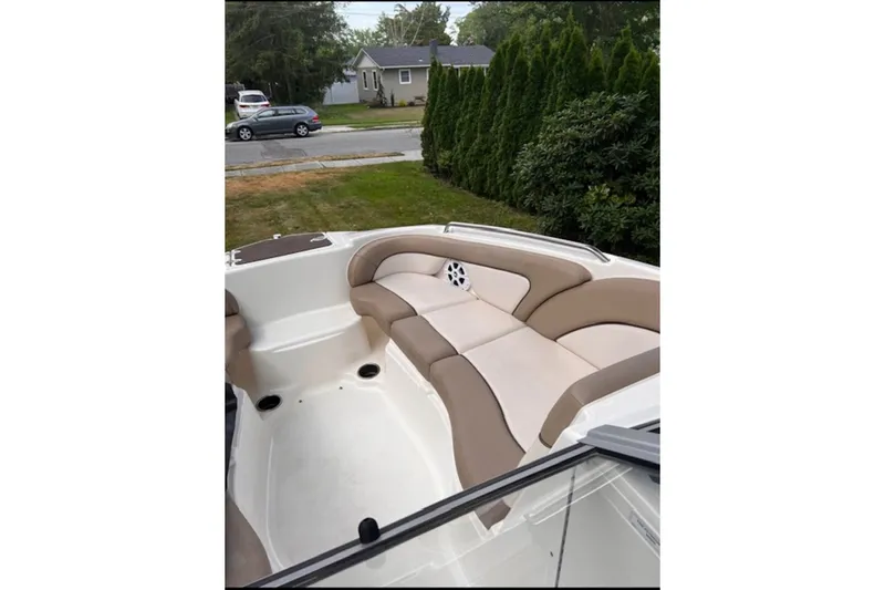 Slide: The Image of 2011 Yamaha Boats SX240 HO interior with beige seating, parked near a residential area. - 2
