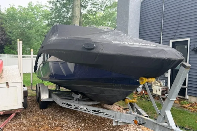 Slide: The Image of 2011 Yamaha Boats SX240 HO on trailer, covered, parked beside a house. - 4