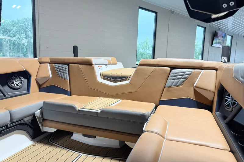 Slide: The Image of Interior of 2022 Nautique Super Air Nautique S23 with luxurious tan and gray seating. - 15