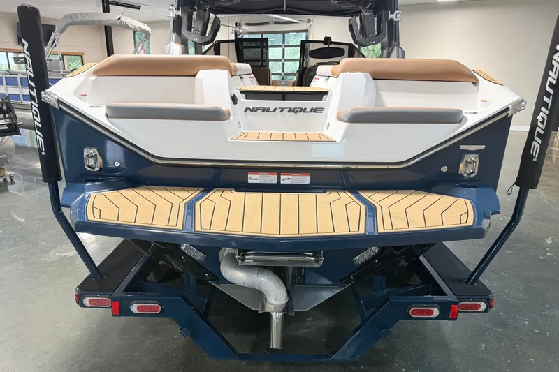 Slide: The Image of 2022 Nautique Super Air Nautique S23 boat rear view with teak deck and branding. - 8