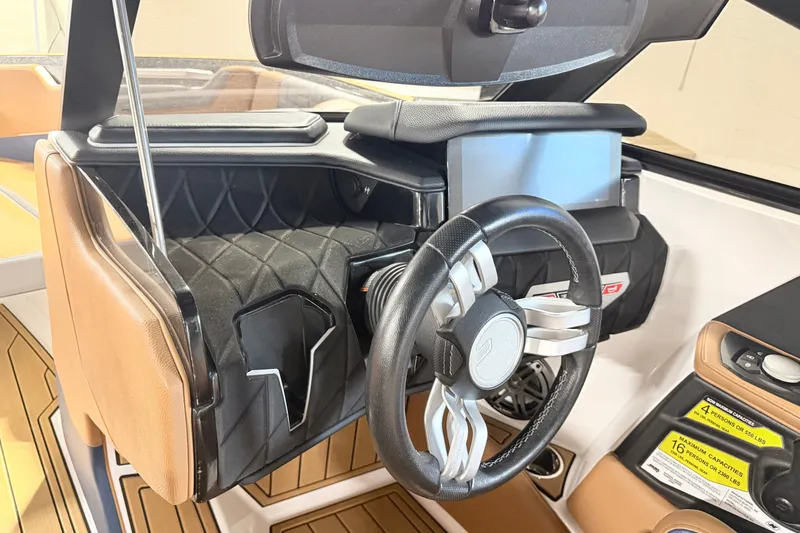 Slide: The Image of 2022 Nautique Super Air Nautique S23 dashboard with steering wheel and control panel. - 34