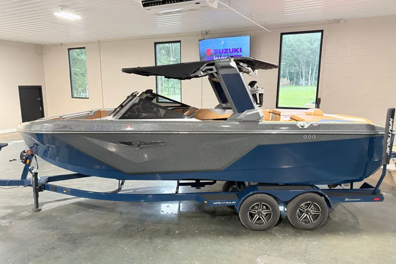 Slide: The Image of 2022 Nautique Super Air Nautique S23 boat in showroom, featuring sleek design and blue exterior. - 5
