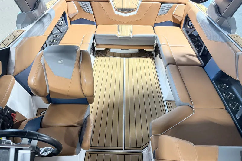Slide: The Image of 2022 Nautique Super Air Nautique S23 interior with tan leather seating and wood flooring. - 29