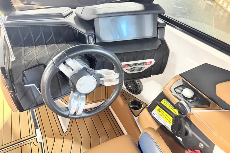 Slide: The Image of 2022 Nautique Super Air Nautique S23 dashboard with steering wheel and control panel. - 21
