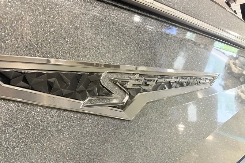 Slide: The Image of 2022 Nautique Super Air Nautique S23 emblem on a metallic finish surface. - 25