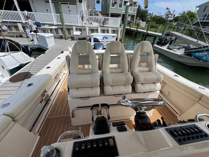 Slide: The Image of The image shows the cockpit of a 2016 Grady-White Canyon 336 boat with three beige seats. - 16