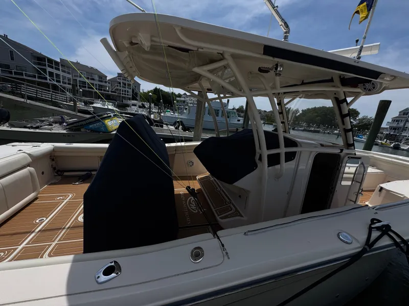 Slide: The Image of The image shows a 2016 Grady-White Canyon 336 boat docked in a marina with surrounding buildings. - 33