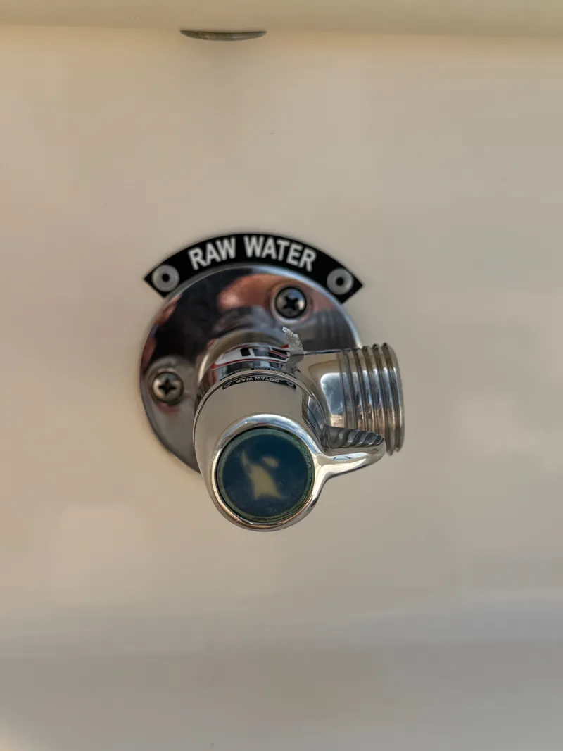 Slide: The Image of A chrome water fitting labeled "RAW WATER" on a boat. - 24