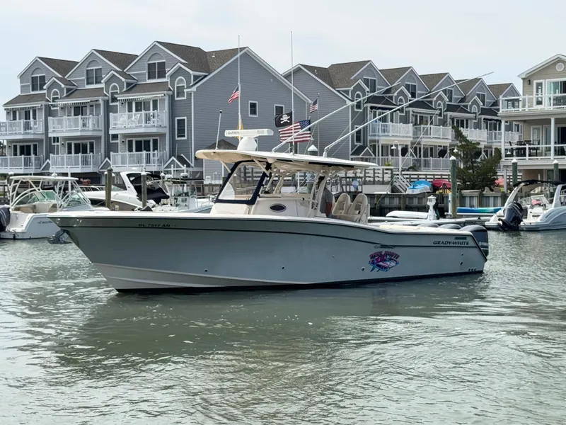 Slide: The Image of A 2016 Grady-White Canyon 336 boat is on the water in front of several houses. - 6