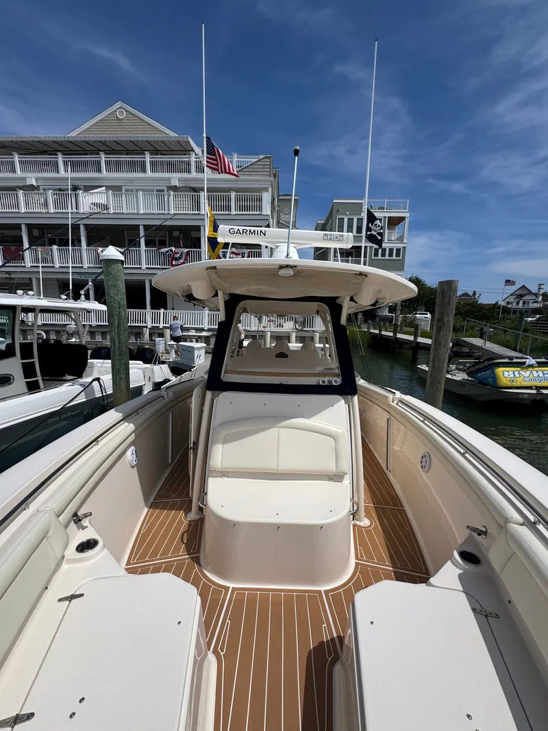 Slide: The Image of A 2016 Grady-White Canyon 336 docked in a marina. It features a spacious deck and modern amenities. - 21