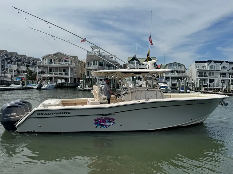 Slide: The Image of A 2016 Grady-White Canyon 336 boat on the water, with houses in the background. - 4