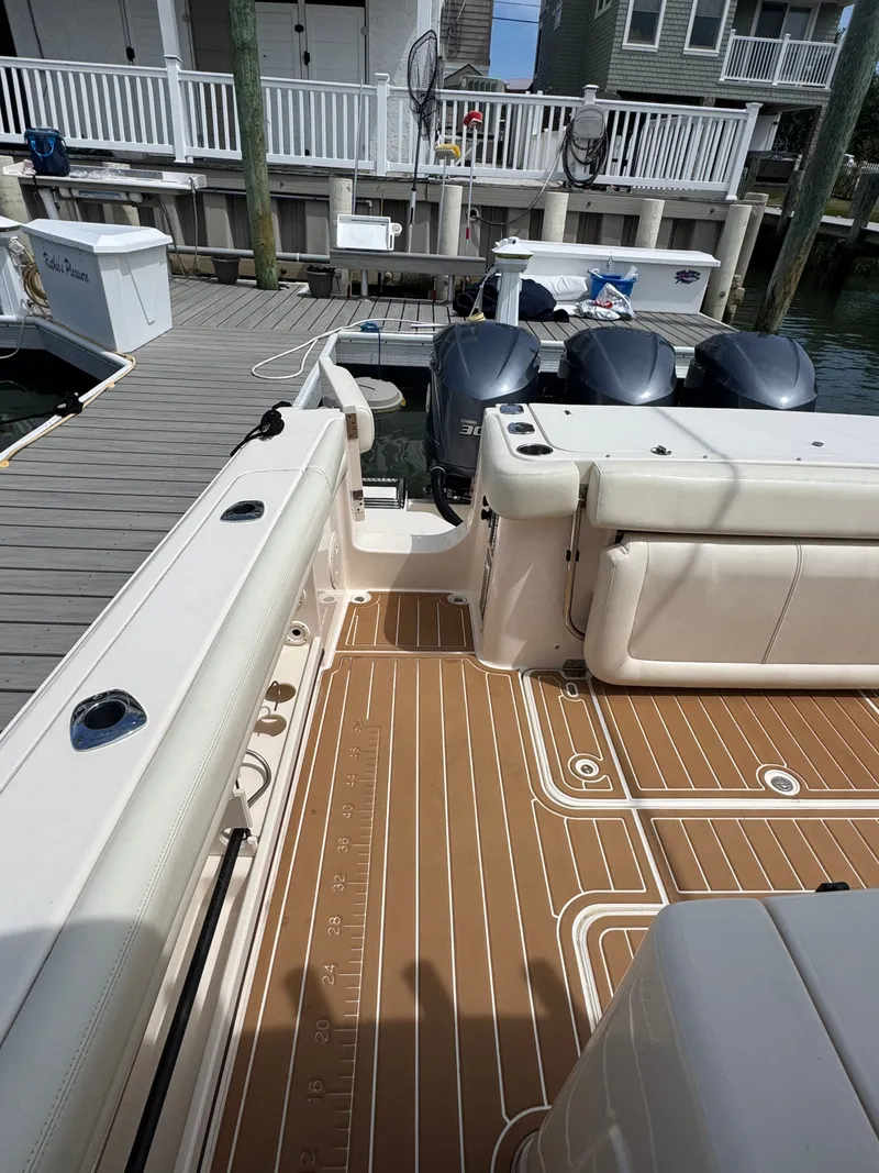 Slide: The Image of Grady-White Canyon 336 at dock with three outboard engines and spacious cockpit. - 18