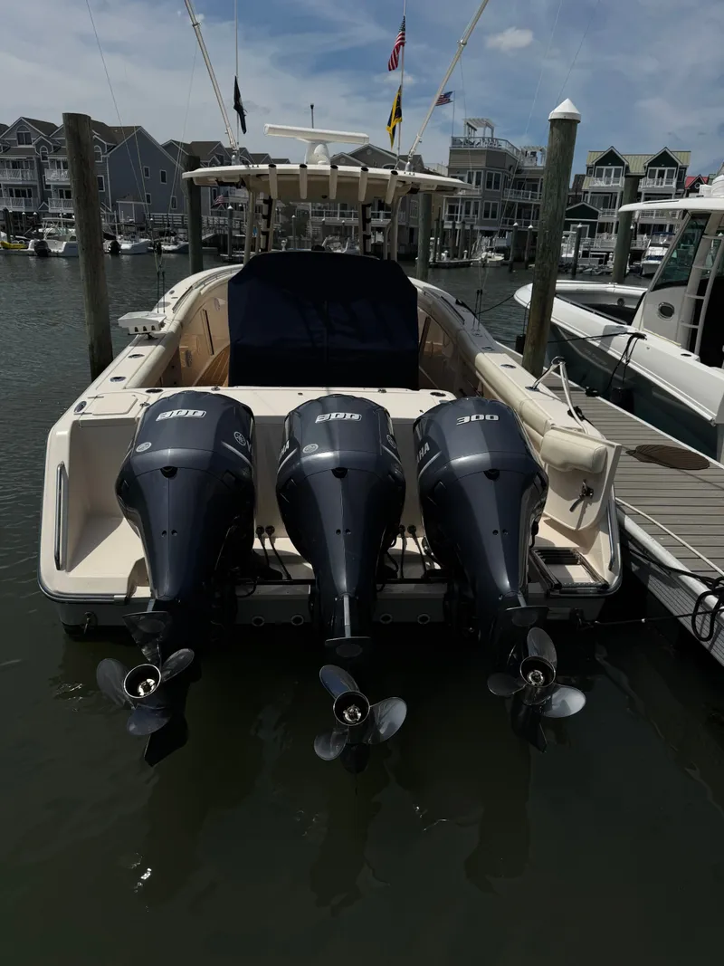 Slide: The Image of A 2016 Grady-White Canyon 336 with three outboard engines, docked in a marina. - 32