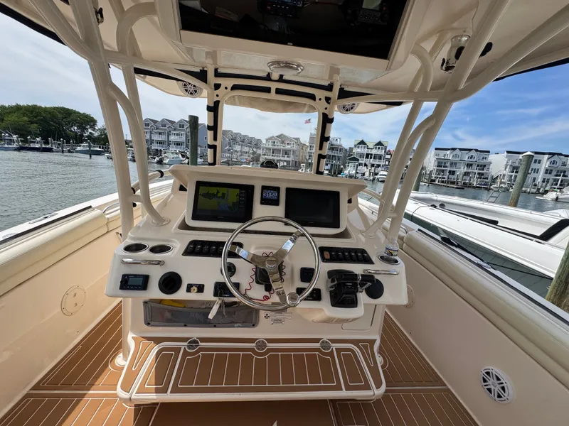 Slide: The Image of The cockpit of a 2016 Grady-White Canyon 336 with modern navigation systems and controls. - 14