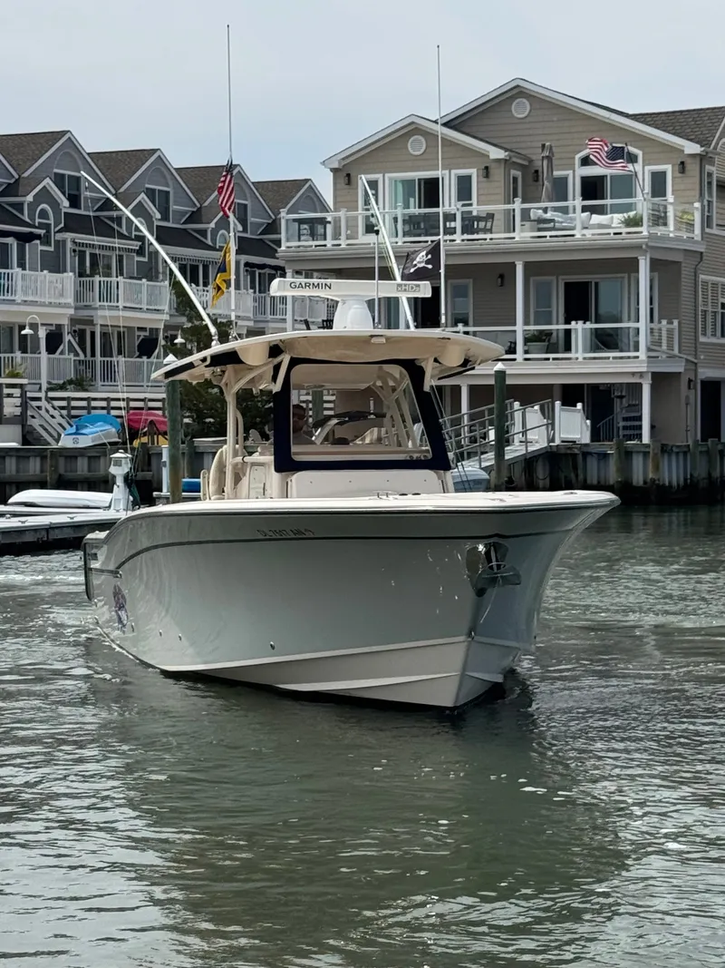 Slide: The Image of A 2016 Grady-White Canyon 336 navigates a waterway in front of modern houses. - 9