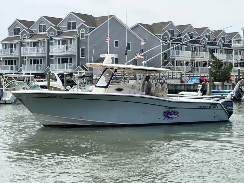 Slide: The Image of A 2016 Grady-White Canyon 336 is docked in the water near a residential complex. - 2