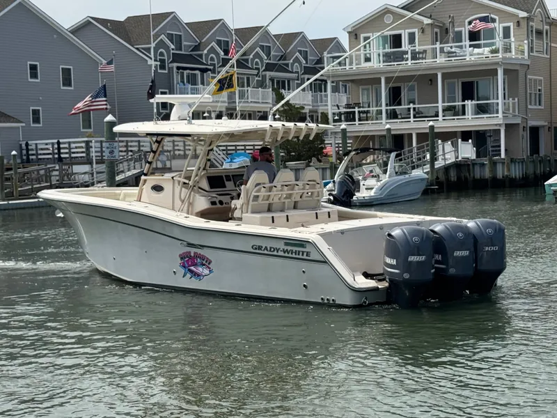 Slide: The Image of A 2016 Grady-White Canyon 336 navigates a waterway. It features three outboard engines. - 5
